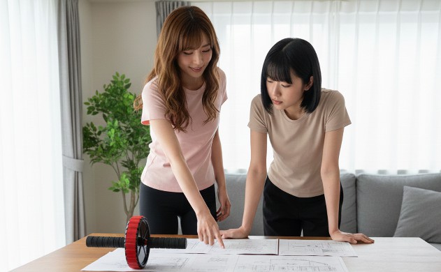 「怪我モードごとの『原因 → 発生メカニズム → 安全対策』まとめ」
あいみが机の上に並べた図解資料を指し示しながら、美羽に説明。美羽は真剣な表情。腹筋ローラーは資料の横。