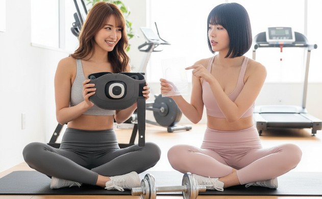 「EMS腹筋ベルトの方式はどう進化してきたのか」 → あいみはジェル不要型EMSベルトを手に持ち、美羽はジェルシートを指でツンツンして確認している。2人が並んで方式の違いを比較している。