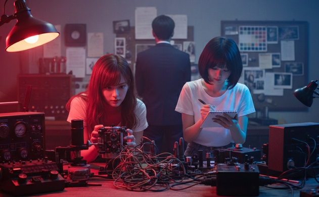 色セロハンで異様な色彩に染まったレトロな暗室にて、複雑な配線の実験装置を覗き込むあいみと、メモを取る美羽。その背後では佐藤誠が腕組みをして静かに見守り、長年の経験が蓄積された「実験場」の重みと、世代を超えた探究心が交差する瞬間。